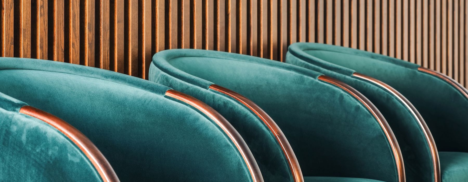 a row of chairs in front of a slat wall