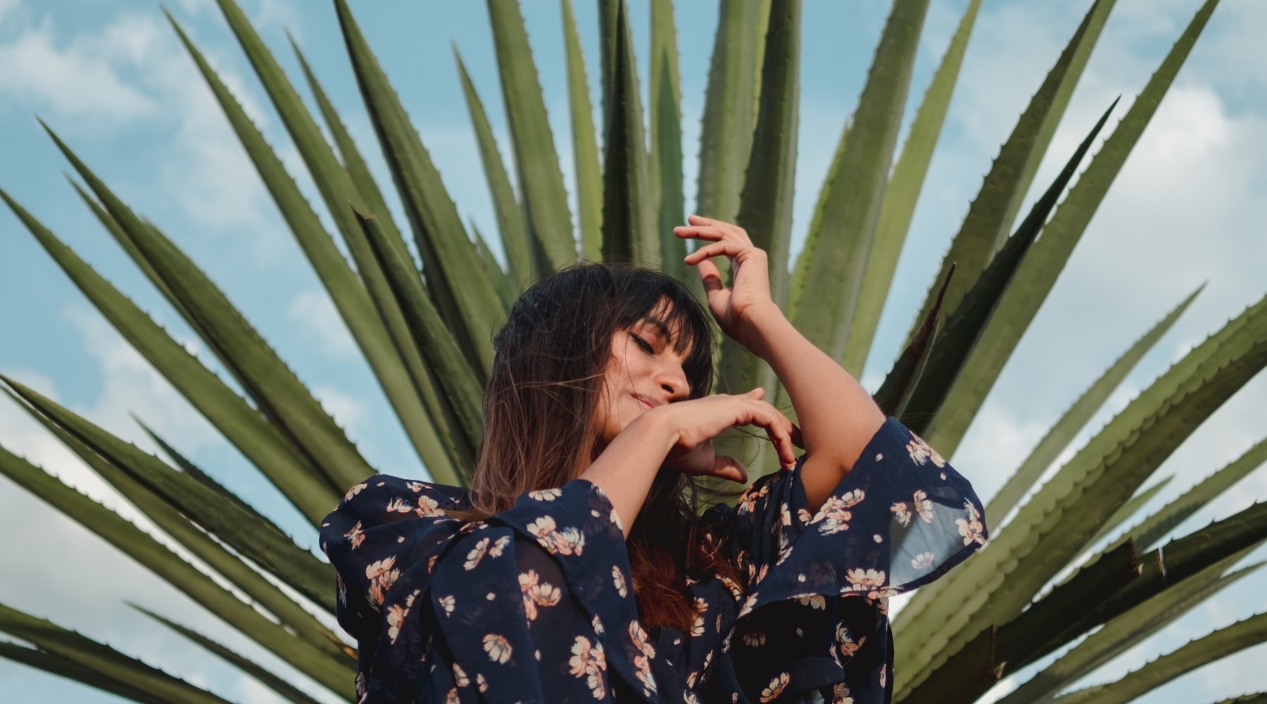 a person dancing in front of a plant outdoors
