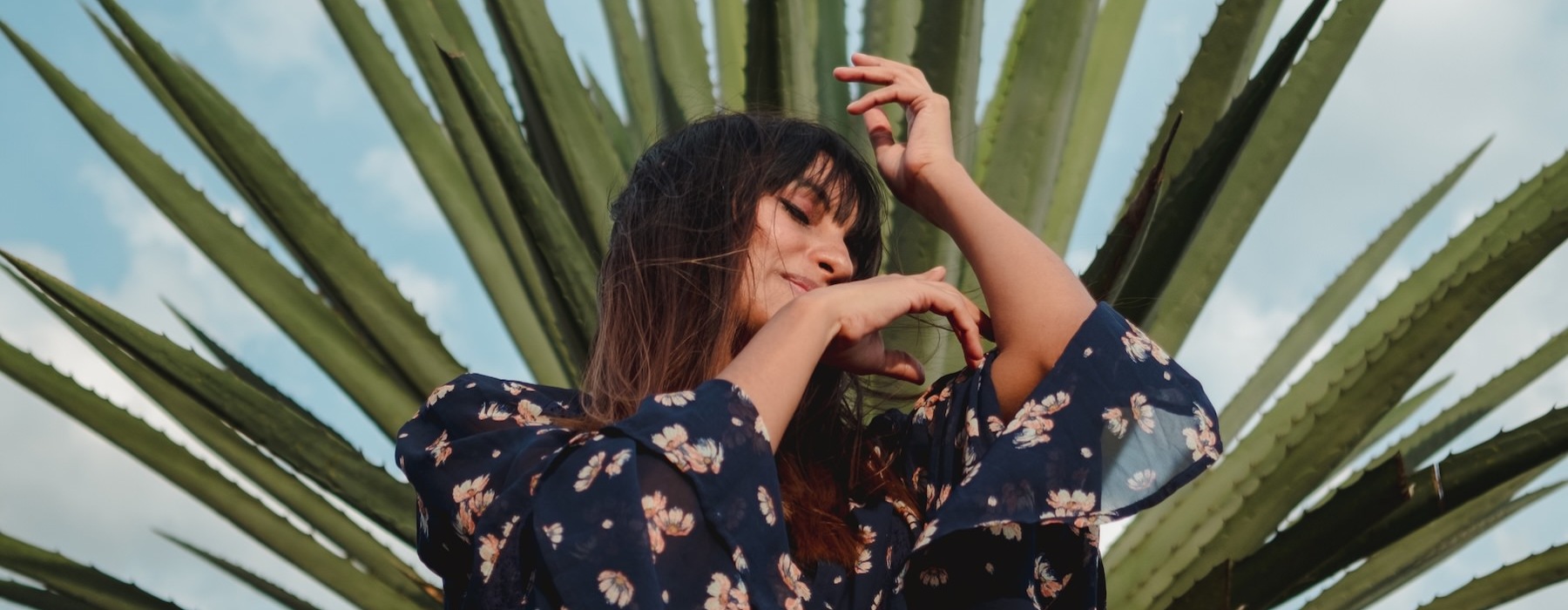 a person dancing in front of a plant outdoors