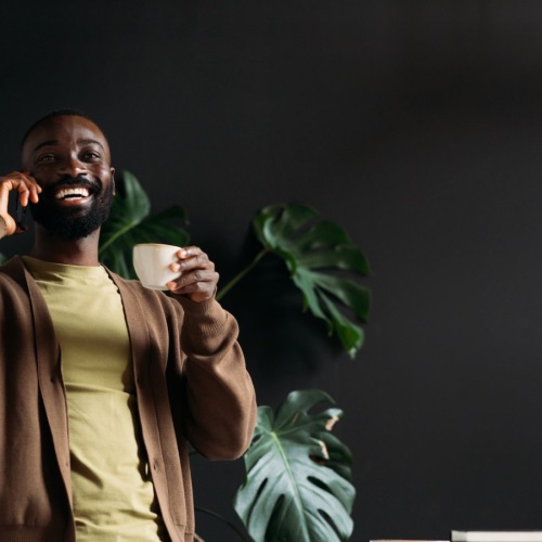 a person on the phone laughing holding a cup