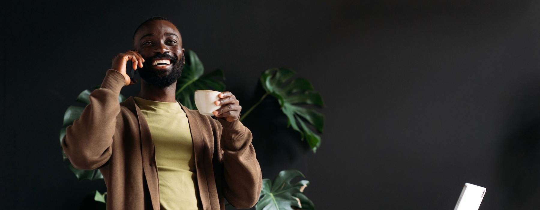 a person on the phone laughing holding a cup